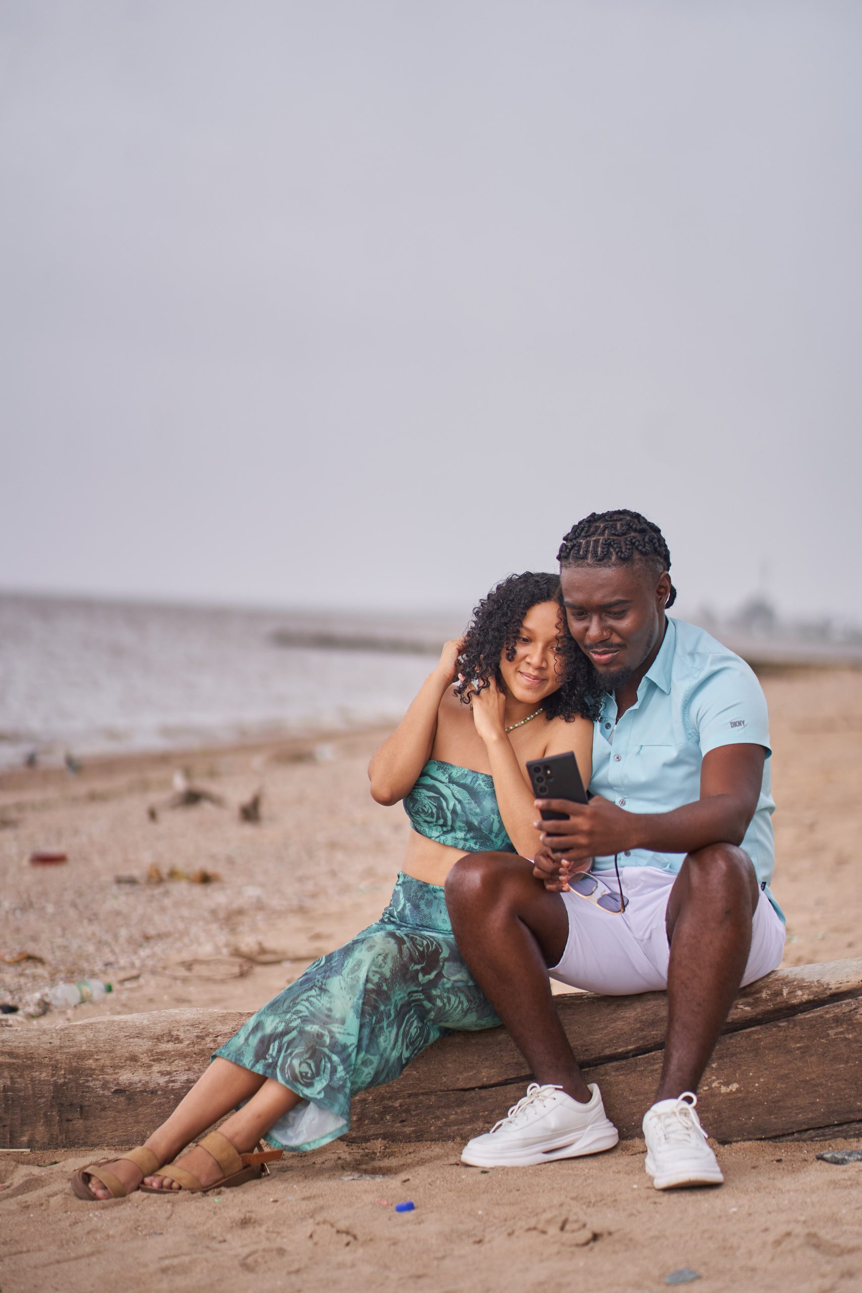 A couple relaxed on seashore watching in mobile